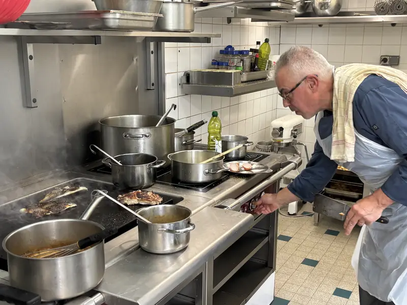Le chef aux fourneaux dans la cuisine du restaurant Aux Tilleuls
