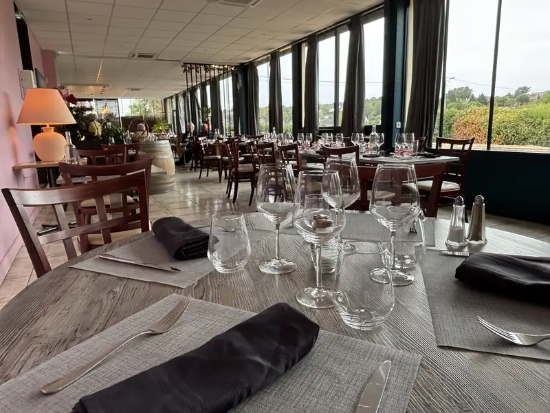 Table dressée devant les baies vitrées du restaurant